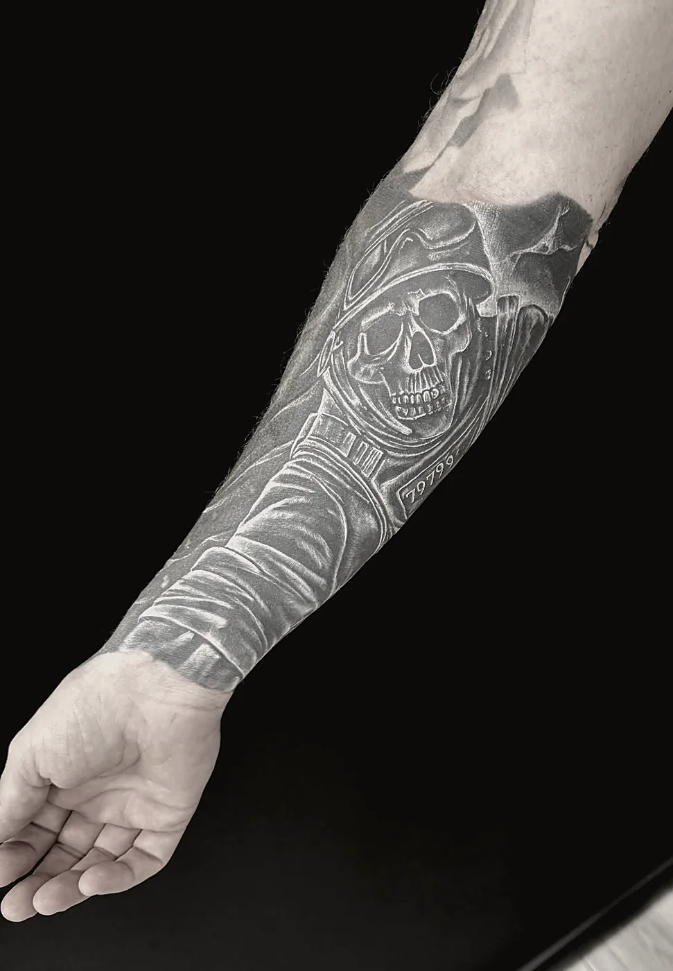 Black and grey realism sleeve tattoo on forearm, healed skin